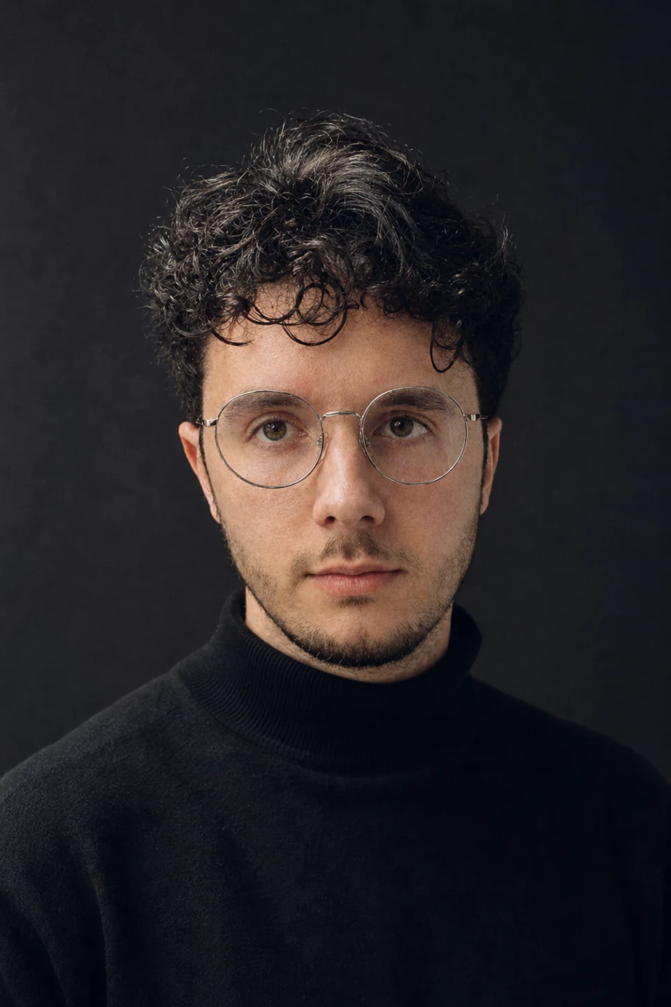 Portrait of Safouan Aouezghar, wearing round glasses and a black turtleneck